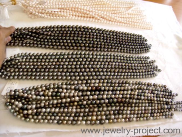 Rangs de perles mixtes, grises et blanches. Chaque rang représente 2.000 à 5.00 USD.